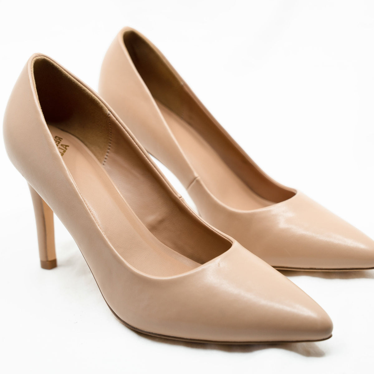 Close-up of a pair of Rebecca Allen The Point pointed-toe pumps in Nude IV, a light beige, shown from the front three-quarter angle